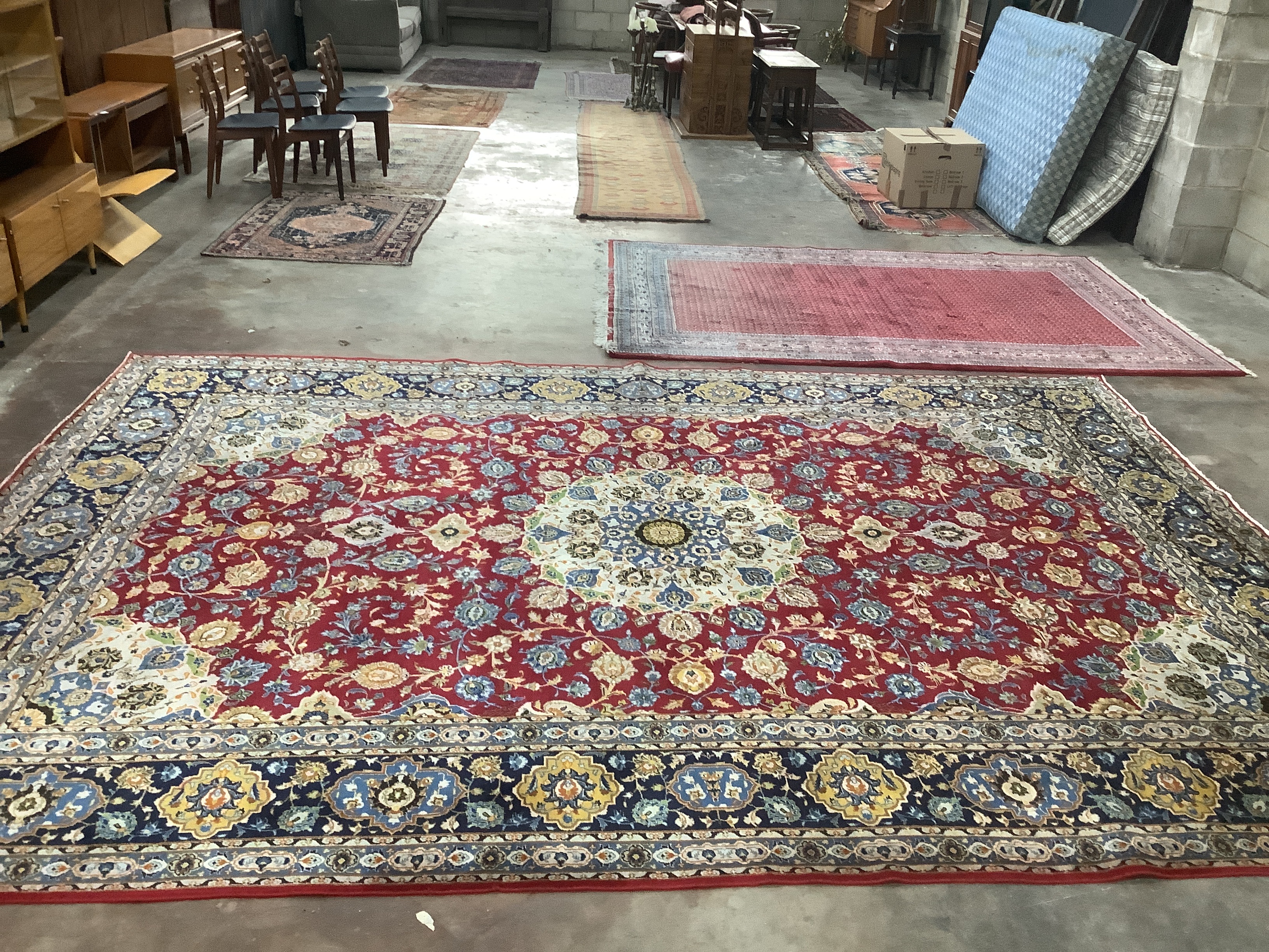 An Isphanan crimson ground carpet with central medallion and field of foliate motifs, multi-bordered, 425 x 300cm